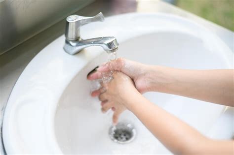 Premium Photo A Woman Washes Her Hands With Soap