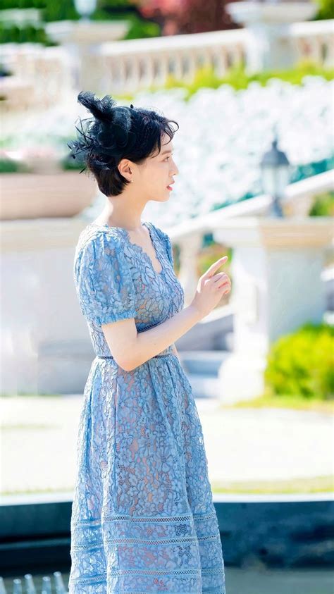 A Woman In A Blue Dress Is Standing Outside