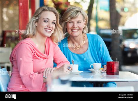 Caucasian Mother And Daughter Drinking Coffee At Sidewalk Cafe Stock