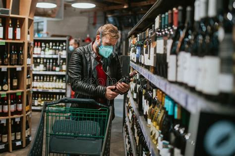 Un Homme Dans Un Supermarché Pousse Un Chariot Entre Les étagères Image