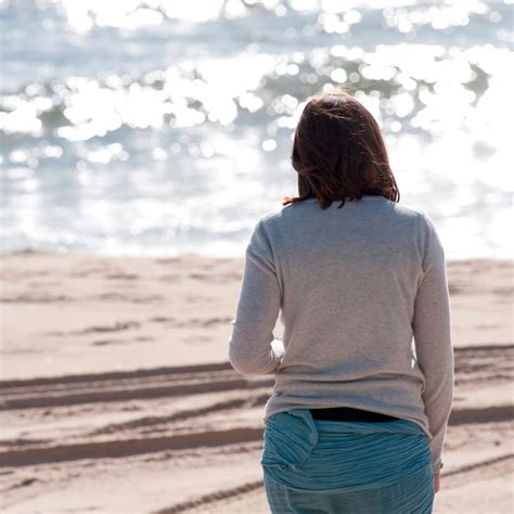 Vista Traseira De Um Mulher Caminhando Ao Longo A Praia Em A