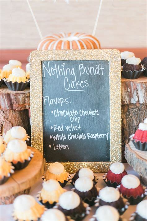 A Table Topped With Lots Of Cupcakes Next To A Chalkboard Sign That Says Nothing Bundt Cakes