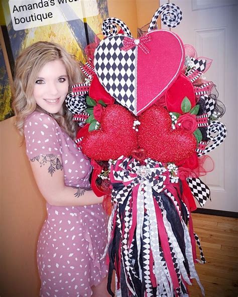 A Woman Standing Next To A Heart Shaped Arrangement