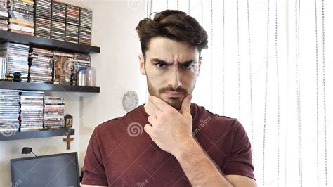 Confused Young Man Scratching His Chin Looking At Camera Stock Image