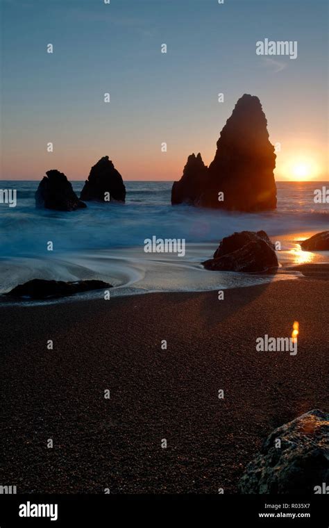 Rocky beach at sunrise Stock Photo - Alamy