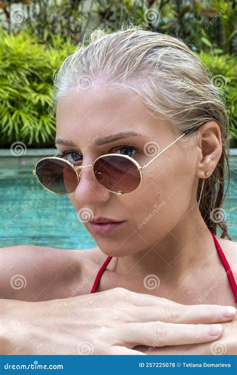 Vertical Portrait Of Confident Woman In Pool Seductively Looking Into Camera Woman Wearing