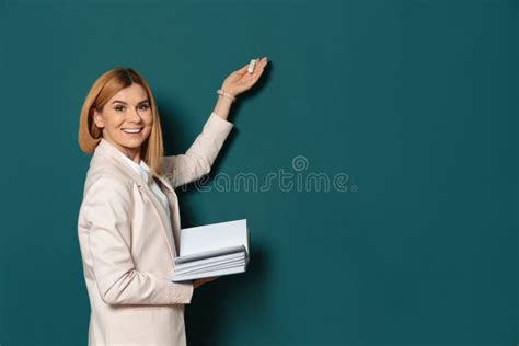 Beautiful Teacher With Book Pointing At Chalkboard Stock Photo Image