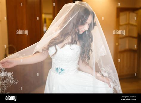 Pretty Bride Puts On Her Wedding Dress In The Room Stock Photo Alamy