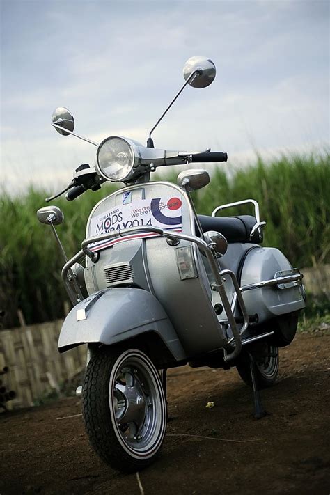 A Silver Motorcycle Parked On Top Of A Dirt Road