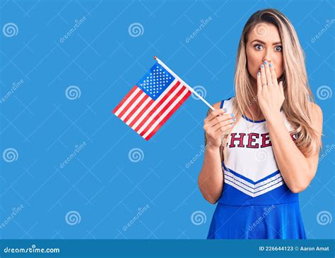 Young Beautiful Blonde Woman Wearing Cheerleader Uniform Holding United