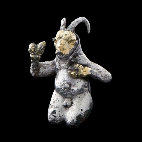 A Proto Elamite Silver Gilt Kneeling Goat Headed Anthropomorphic Deity