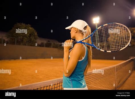 Side View Portrait Of Sports Woman Holding Tennis Racket At Court Stock