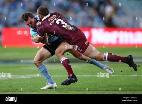 Clint Gutherson of the Blues is tackled by Kurt Capewell of the Maroons