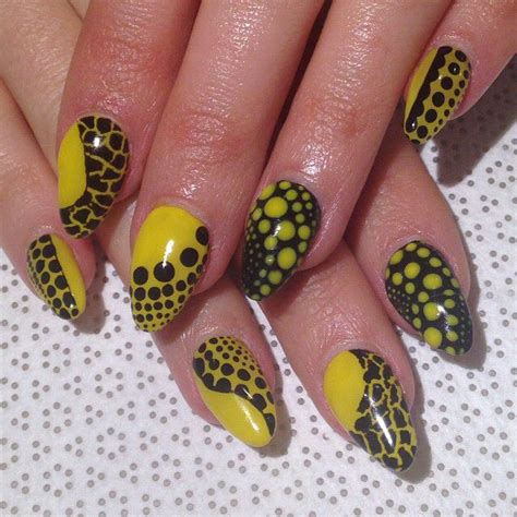 A Woman S Hand With Yellow And Black Polka Dot Nail Art Designs On It