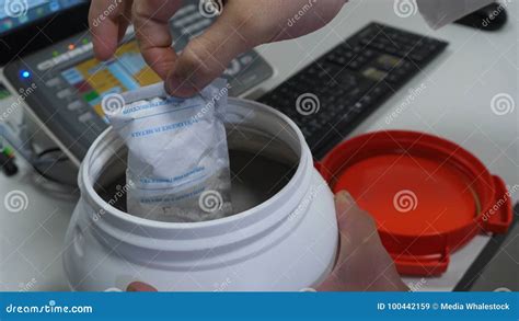 Scientist In A White Lab Coat Putting Vial With A Sample Into