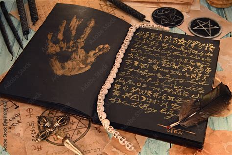 Open Grimoire Book Of Magic Spells With Black Candles On Witch Table