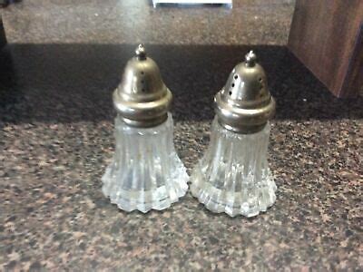 Two Glass Salt And Pepper Shakers Sitting On A Counter