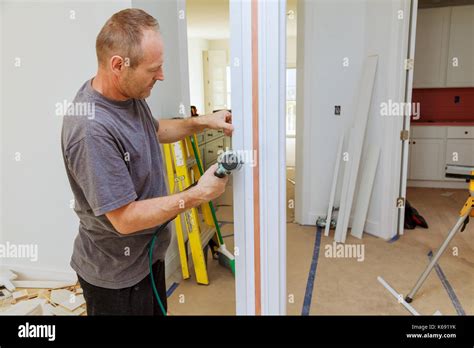 Carpenter Using A Brad Nail Gun To Complete Framing Trim Air Gun For