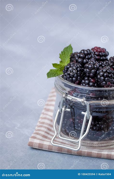 Closeup Of Fresh Blackberries With A Mint Leaf In A Glass Jar On Rustic