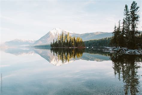 Sunrise Light On A Still Mountain Lake Illuminating An Island By