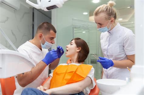 Premium Photo Dentist With Assistant Examines The Oral Cavity Of