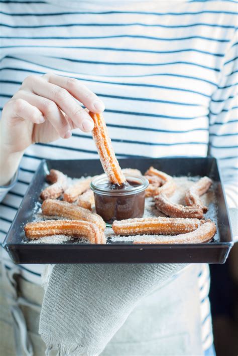 Churros Con Salsa Di Cioccolato Fondente Al Peperoncino Con Le Mani