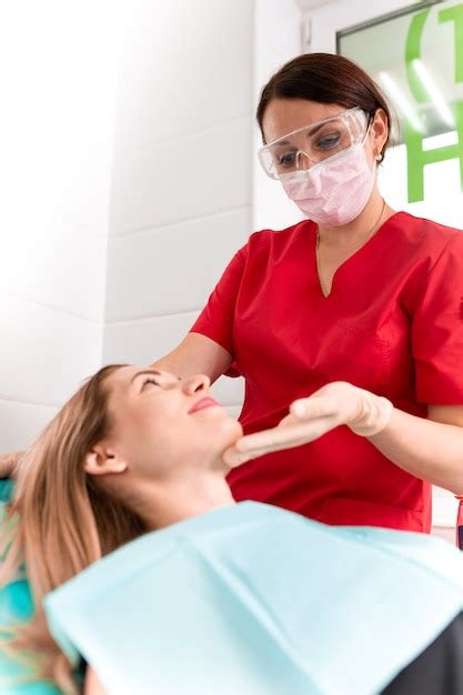 Premium Photo A Female Dentist Examines The Oral Cavity Of The