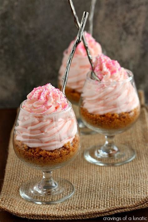 Three Small Desserts With Pink Frosting In Glass Cups On A Burlap Cloth