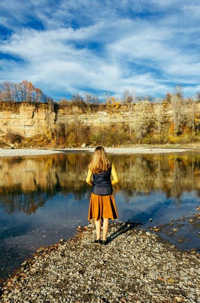 Premium Photo Young Blonde Girl With Loose Hair Stands On The River Bank