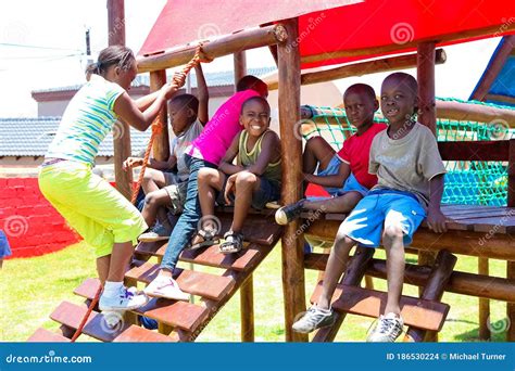 African Kids Playing On Jungle Gym And Other Park Equipment At Local