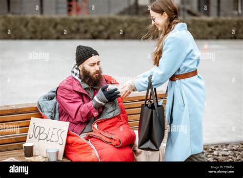 Smiling Woman Helping Homeless Beggar Giving Some Food Outdoors