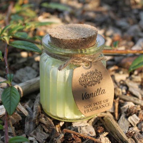 A Small Jar Filled With Sand Sitting On The Ground Next To Some Leaves