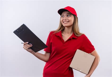 Olhando para o lado a jovem entregadora de uniforme vermelho e boné