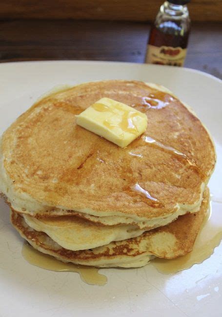 a stack of pancakes with butter and syrup on top, sitting on a white plate