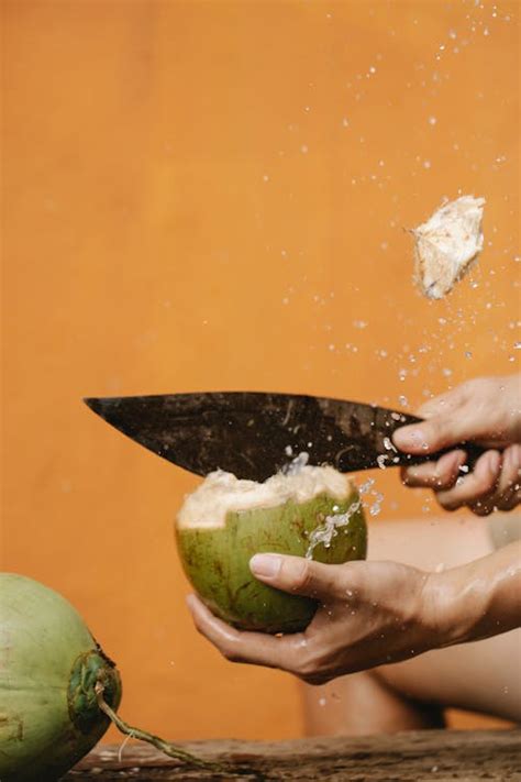 Crop person cutting coconut with knife · Free Stock Photo