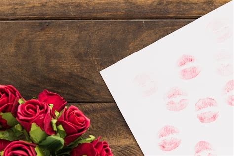 Free Photo | Lipstick kisses on paper near beautiful flowers