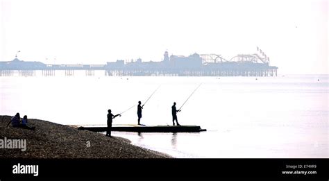 Fishermen Cast Their Lines Off Brighton Beach In Beautiful Warm