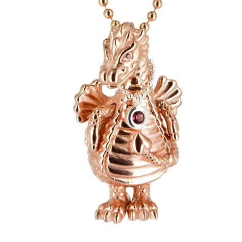 A Gold Necklace With A Dragon On It S Face And An Eye In The Center