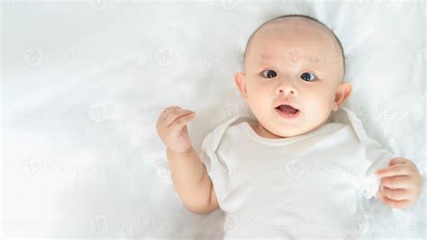 happy family cute asian newborn baby boy lying play  white bed