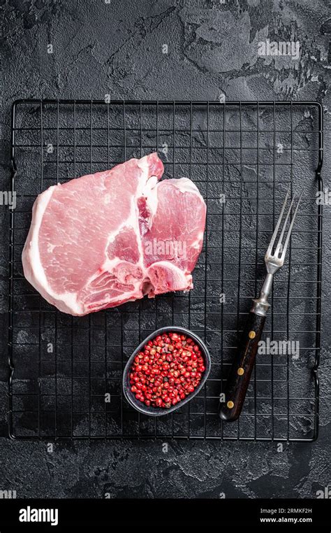 Uncooked Raw Pork T Bone Chop Meat Steak On Grill Black Background