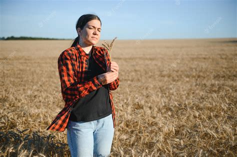 Premium Photo | Farmer woman working in wheat field at sunset ...