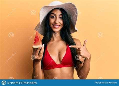 Beautiful Hispanic Woman Wearing Bikini Eating Watermelon Pointing