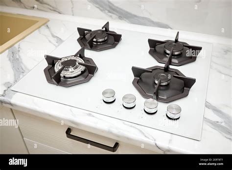 Modern gas stove on counter top white closeup. Hob gas stove using ...