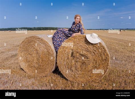 Une Jeune Fille Blonde Aux Cheveux Longs Dans Un Chapeau Blanc Se Repose Et Pose Pr S Des Gerbes