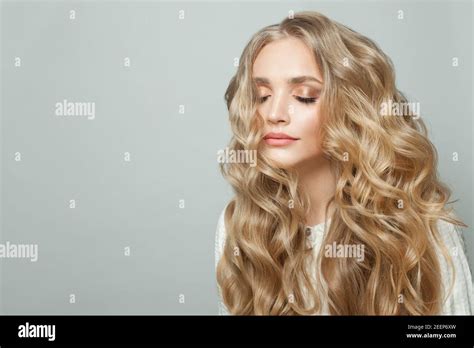 Attractive Woman With Long Blonde Healthy Curly Hair On White