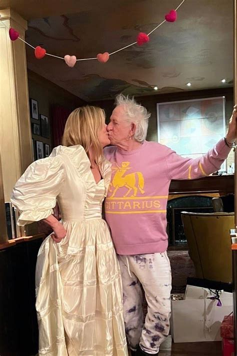 An Older Man And Woman Are Kissing In Front Of A Bar With Hearts