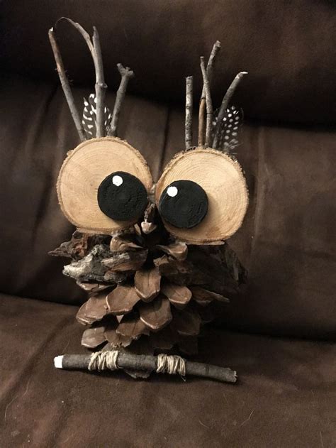 An Owl Figurine Made Out Of Wood And Branches With Eyes Painted On It