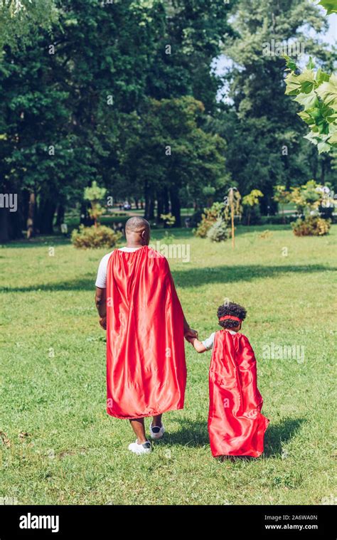 Back View Of African American Father And Son Holding Hands While