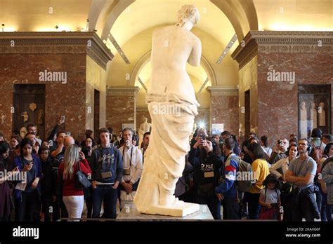 Visitors Look And Take Pictures Of The Ancient Greek Sculpture Venus