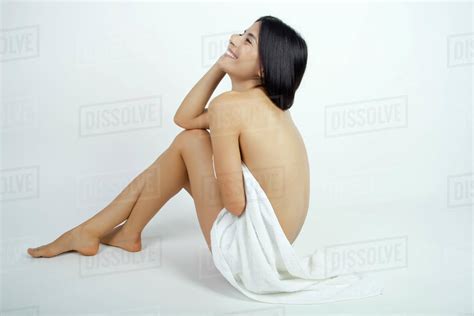 Nude Woman Partially Covered With Towel Sitting On Floor Daydreaming Stock Photo Dissolve